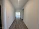 Bright hallway showcasing sleek wood-style tile floors, fresh paint, and recessed lighting at 47251 W Mellen Ln, Maricopa, AZ 85139