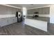 This kitchen features granite countertops, an island, stainless steel appliances, and gray cabinets at 47251 W Mellen Ln, Maricopa, AZ 85139