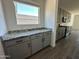 Modern kitchen features gray cabinets, granite countertops, and stainless steel appliances, offering style and functionality at 47251 W Mellen Ln, Maricopa, AZ 85139