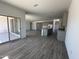 Open-concept living area with wood floors seamlessly connects the kitchen, dining, and living spaces, great for entertaining at 47251 W Mellen Ln, Maricopa, AZ 85139