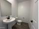 The half-bathroom features a pedestal sink, tile floor, and neutral paint at 47251 W Mellen Ln, Maricopa, AZ 85139