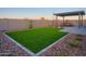Low maintenance backyard with pavers, artificial grass and shaded seating area at 4924 W Capistrano Ave, Laveen, AZ 85339