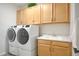 Functional laundry room equipped with modern washer and dryer, ample storage, and a utility sink for convenience at 4924 W Capistrano Ave, Laveen, AZ 85339