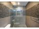 Modern bathroom with a pebble-stone shower, tiled walls and gray vanity with stone countertop at 4950 N Miller Rd # 122, Scottsdale, AZ 85251
