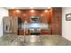 Close-up of kitchen with stainless steel appliances, a sink with a chrome faucet, and dark-stained wood cabinets at 4950 N Miller Rd # 122, Scottsdale, AZ 85251