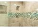 Modern shower with stone tiles and decorative blue and brown round glass tiles at 4950 N Miller Rd # 122, Scottsdale, AZ 85251
