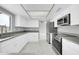 Modern kitchen featuring bright white cabinets, stainless steel appliances, and sleek countertops at 5228 W Ironwood Dr, Glendale, AZ 85302