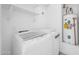 Functional laundry area with modern washer and dryer, additional shelving, and a water heater at 5228 W Ironwood Dr, Glendale, AZ 85302