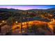 Aerial night view of a single-story home featuring landscape lighting, a backyard, and mountain views at 5480 E Desert Creek Ln, Cave Creek, AZ 85331