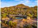 Aerial view of a desert home with a pool, outdoor patio, and lush landscaping at 5480 E Desert Creek Ln, Cave Creek, AZ 85331