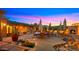 Charming backyard patio with a stone fireplace, lush landscaping, and comfortable seating arrangements at 5480 E Desert Creek Ln, Cave Creek, AZ 85331