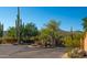 Community entrance featuring desert landscaping, brick signage, a paved road and gate leading into the community at 5480 E Desert Creek Ln, Cave Creek, AZ 85331