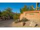 Community entrance featuring desert landscaping, brick signage, a paved road and gate leading into the community at 5480 E Desert Creek Ln, Cave Creek, AZ 85331