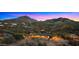 Expansive Arizona home with a pool and desert landscaping set against a beautiful mountain backdrop at sunset at 5480 E Desert Creek Ln, Cave Creek, AZ 85331