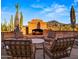 Cozy brick outdoor fireplace surrounded by comfortable seating and scenic desert views, perfect for relaxation at 5480 E Desert Creek Ln, Cave Creek, AZ 85331