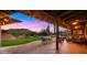 Charming covered patio with a ceiling fan, brick columns, and an outdoor dining area that overlooks the grassy yard and mountain view at 5480 E Desert Creek Ln, Cave Creek, AZ 85331