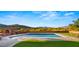 Sparkling pool with a built-in brick fireplace and beautiful mountain backdrop at 5480 E Desert Creek Ln, Cave Creek, AZ 85331