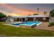 A backyard featuring a swimming pool, lounge chairs, and a covered patio, perfect for outdoor relaxation at 5501 N 1St St, Phoenix, AZ 85012