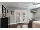 Well-lit bedroom offers wood floors, a black dresser, and double doors to the pool area at 5501 N 1St St, Phoenix, AZ 85012