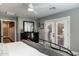 Bright bedroom boasts wood floors, a dark dresser, and double doors to the backyard at 5501 N 1St St, Phoenix, AZ 85012
