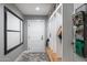 Mudroom featuring white storage lockers, bench, gray walls, and decorative tile flooring at 5501 N 1St St, Phoenix, AZ 85012