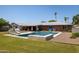 Pool and backyard with poolside seating, umbrellas and a home with brick exterior at 5501 N 1St St, Phoenix, AZ 85012