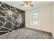 Cozy bedroom with a ceiling fan, plush carpet, and a unique accent wall at 5828 E Hampton Ave, Mesa, AZ 85206