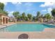 Community pool with surrounding lounge chairs, tables, and landscaped areas at 5828 E Hampton Ave, Mesa, AZ 85206