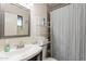 Bathroom features a single sink vanity with chrome faucet, decorative mirror and shelving next to the shower at 660 E 1St Ave, Mesa, AZ 85204