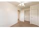 Cozy bedroom with neutral carpet, a ceiling fan, and a closet for organized storage solutions at 660 E 1St Ave, Mesa, AZ 85204