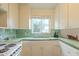 Bright kitchen featuring white cabinetry, vintage green tiles, and a sunny window at 660 E 1St Ave, Mesa, AZ 85204
