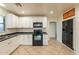 Well-equipped kitchen with white cabinetry, dark countertops, and modern black appliances creating a stylish design at 660 E 1St Ave, Mesa, AZ 85204