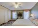 Bedroom featuring a ceiling fan, closet doors, and decorative window valance at 7807 E Main St # H12, Mesa, AZ 85207
