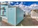 Exterior view showing the side of the light blue mobile home with gravel landscaping and sidewalk access at 7807 E Main St # H12, Mesa, AZ 85207