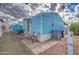 Charming exterior view of a light blue mobile home with a cozy patio and well-maintained landscaping at 7807 E Main St # H12, Mesa, AZ 85207