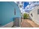 Side exterior view of the light blue mobile home with a gray AC unit and well-kept gravel landscaping at 7807 E Main St # H12, Mesa, AZ 85207