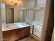 Bathroom with a double sink vanity, medicine cabinet, and a glass enclosed shower at 8179 W Clara Ln, Peoria, AZ 85382