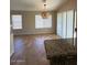 Inviting dining area with tiled floor, granite countertops, modern light fixture, and bright natural light at 8179 W Clara Ln, Peoria, AZ 85382