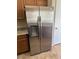 Stainless steel refrigerator with wood cabinets and granite countertops in this kitchen at 8179 W Clara Ln, Peoria, AZ 85382