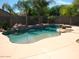 Backyard pool area features lush landscaping and palm trees creating a backyard paradise at 8179 W Clara Ln, Peoria, AZ 85382