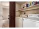 Functional laundry room featuring a washer, a dryer, and storage shelves at 8201 N 21St Dr # C204, Phoenix, AZ 85021