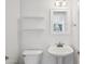 Minimalist half-bathroom with pedestal sink, toilet, and decorative shelving at 9264 E Hillery Way, Scottsdale, AZ 85260