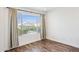 A bright bedroom featuring wood floors, a large window, and neutral decor at 9264 E Hillery Way, Scottsdale, AZ 85260