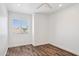 Bright, minimalist bedroom with wood-look floors and a sunlit window at 9264 E Hillery Way, Scottsdale, AZ 85260