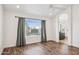 A bright, airy bedroom featuring wood floors, a ceiling fan, and a large window with backyard views at 9264 E Hillery Way, Scottsdale, AZ 85260
