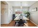 Charming dining room with a long wooden table, modern chandelier, and large window bringing in natural light at 9264 E Hillery Way, Scottsdale, AZ 85260
