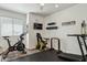 Well-equipped home gym with a stationary bike, treadmill, and wall-mounted fitness accessories at 9264 E Hillery Way, Scottsdale, AZ 85260
