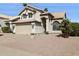 Inviting home featuring a two-car garage, desert landscaping and a cozy front porch with decorative pillars at 9264 E Hillery Way, Scottsdale, AZ 85260