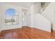 Bright living room with hardwood floors and large arched window providing ample natural light at 9264 E Hillery Way, Scottsdale, AZ 85260