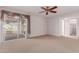Spacious bedroom with a ceiling fan, plush carpeting, and access to outdoor living space at 9730 W Gulf Hills Dr, Sun City, AZ 85351
